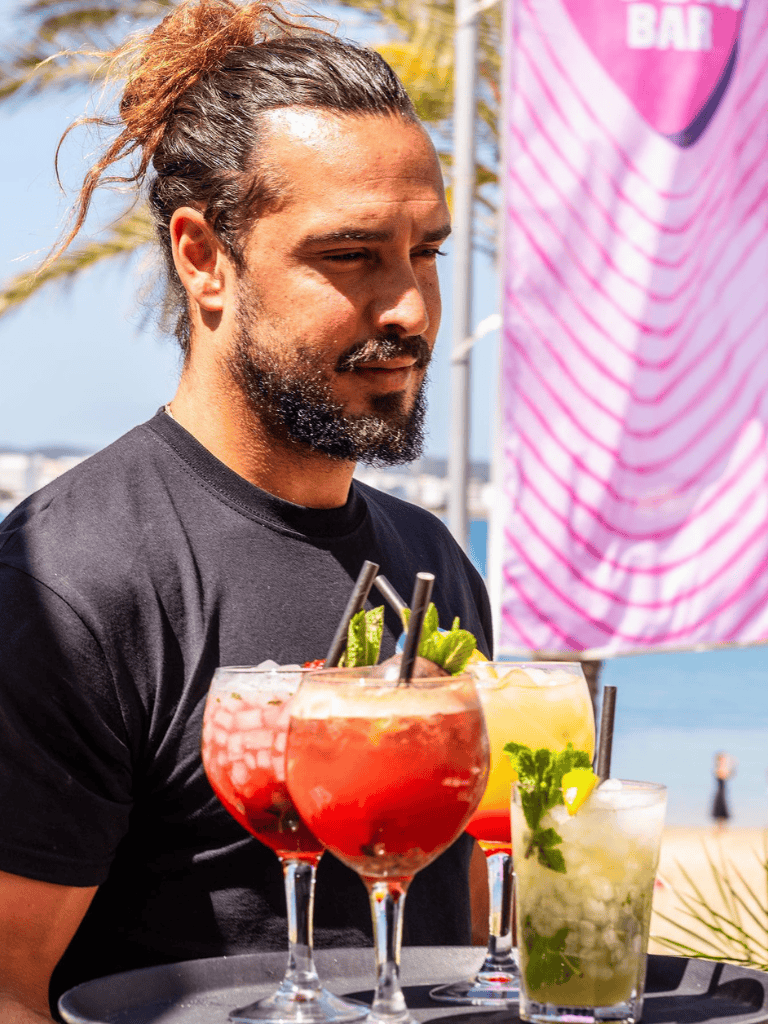 Refreshing summer cocktails served outdoors with a scenic waterfront view.