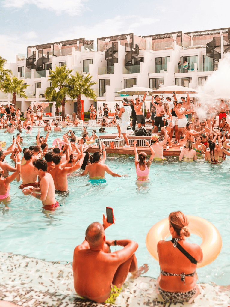 Enjoying a lively pool party at a luxury resort with dancing, socializing, and tropical vibes.