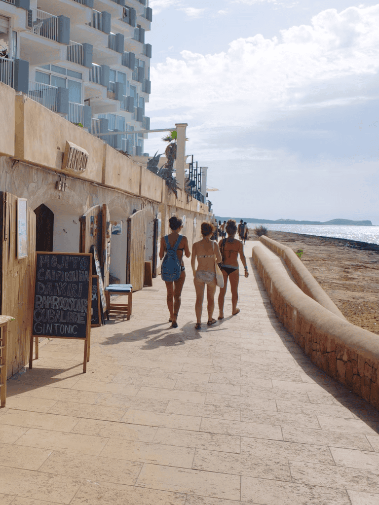 Beachside walk with tourists near coastal hotel for vacation and travel inspiration.