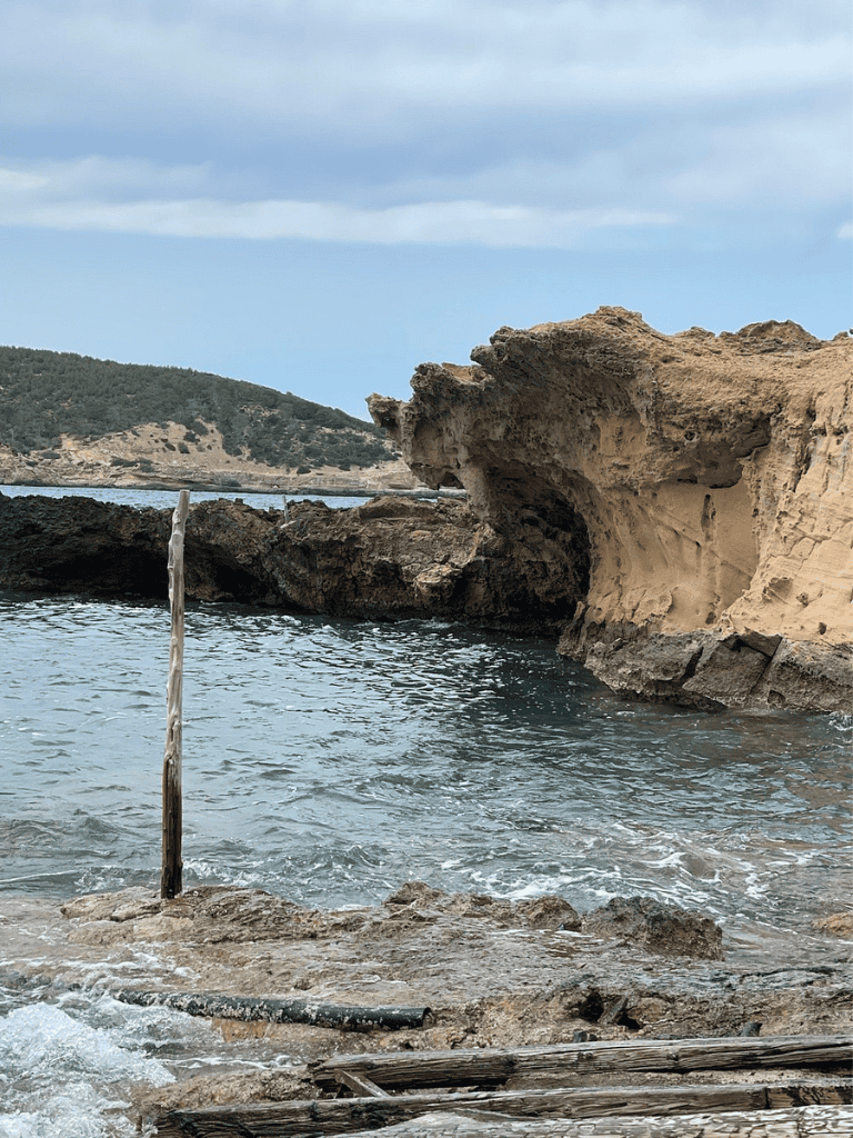 Idyllic coastal rock formation with sea cave and calm waters for exploration.