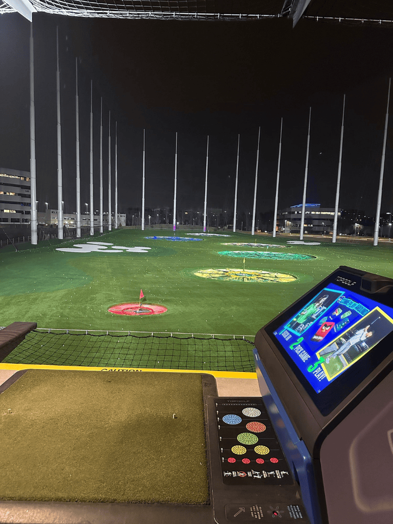 Bright night golf driving range with colorful targets at QuestForDirections.