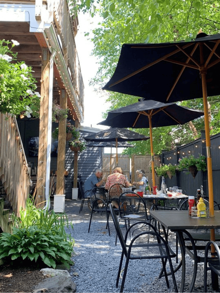 - Cozy outdoor dining area with umbrellas and lush greenery at QuestForDirections.