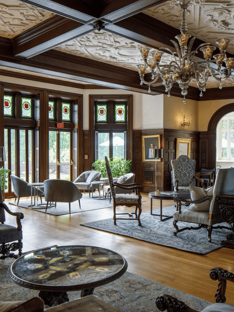 Luxurious vintage-inspired living room with stained glass windows and elegant chandelier.