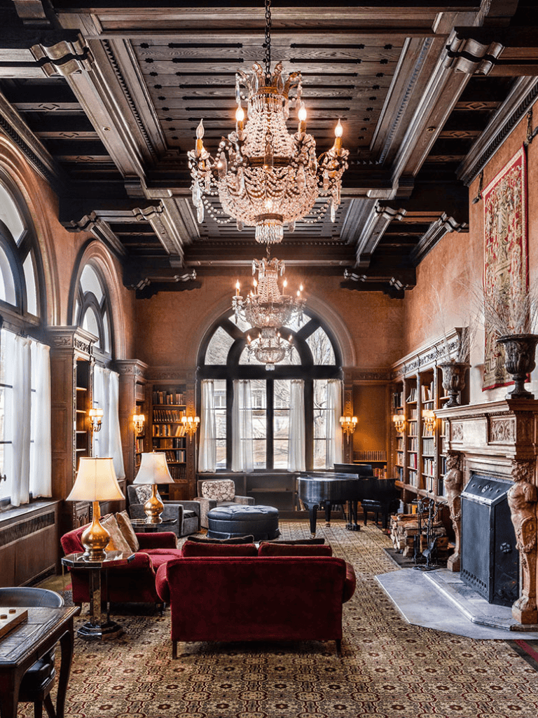 Elegant vintage living room with chandeliers, fireplace, and grand piano for thematic interior design.