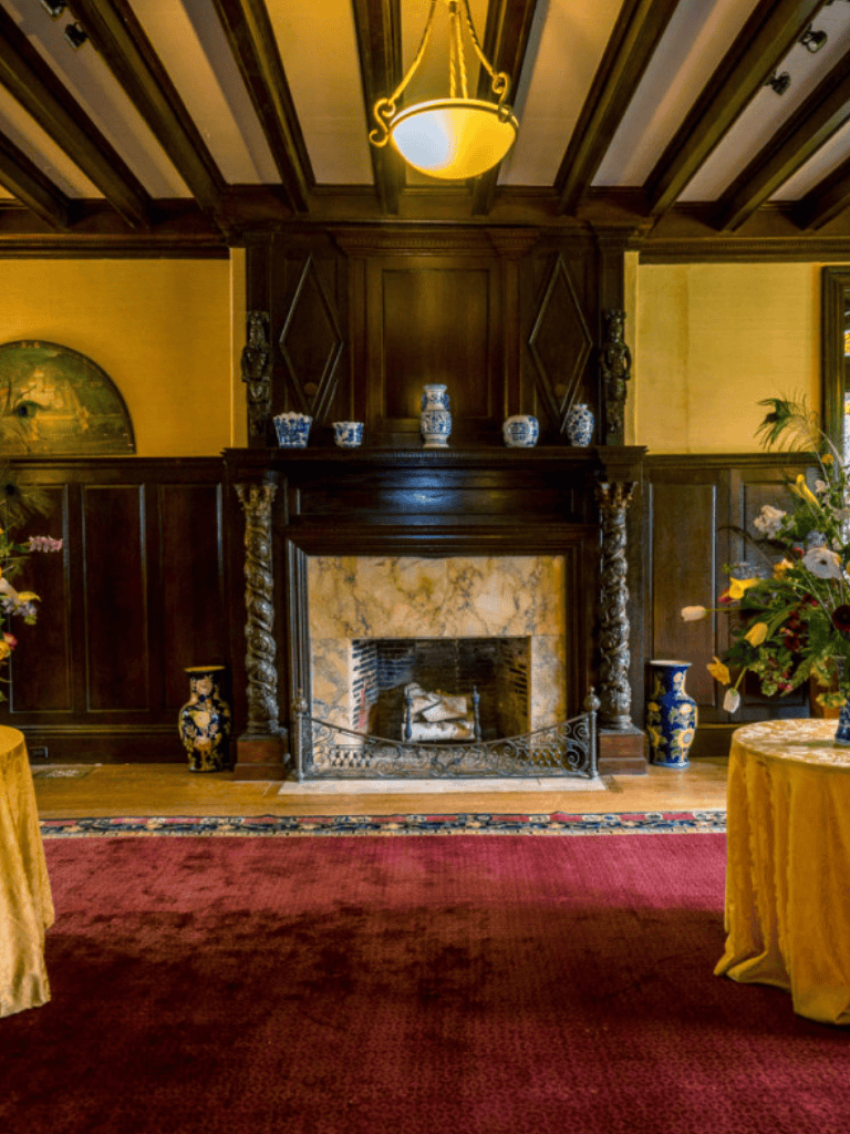 Elegant wood-paneled room with a historic fireplace and vintage decor, perfect for a cozy, upscale gathering.