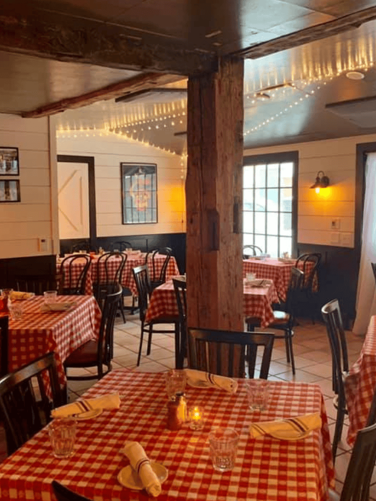 Charming restaurant interior with rustic decor and cozy red checkered tablecloths, inviting for dining experiences.