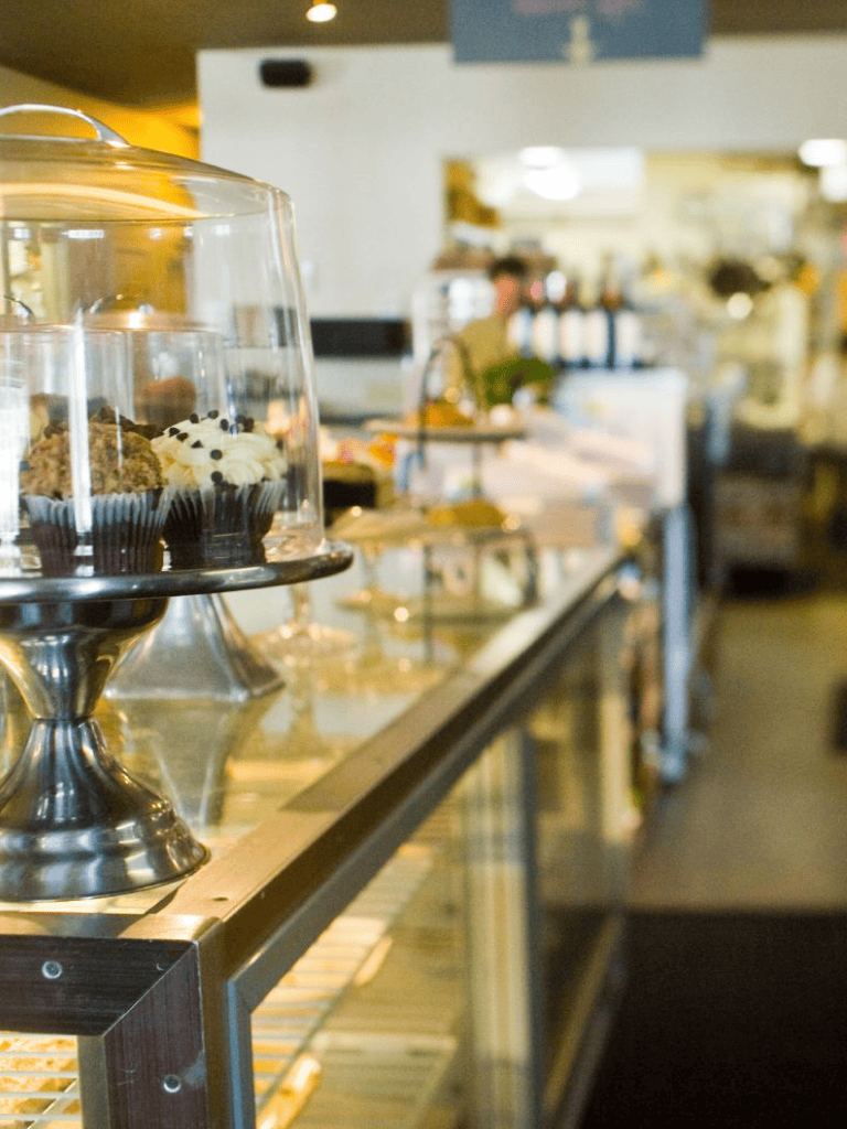 Decadent cupcakes displayed in a bakery case at QuestForDirections. Perfect for sweet tooth cravings and dessert lovers.