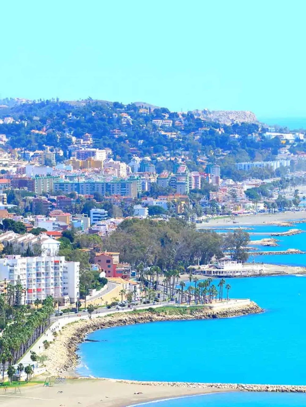 Vibrant coastal cityscape with scenic beach, high-rise buildings, and lush hills, ideal for travel and real estate insights.