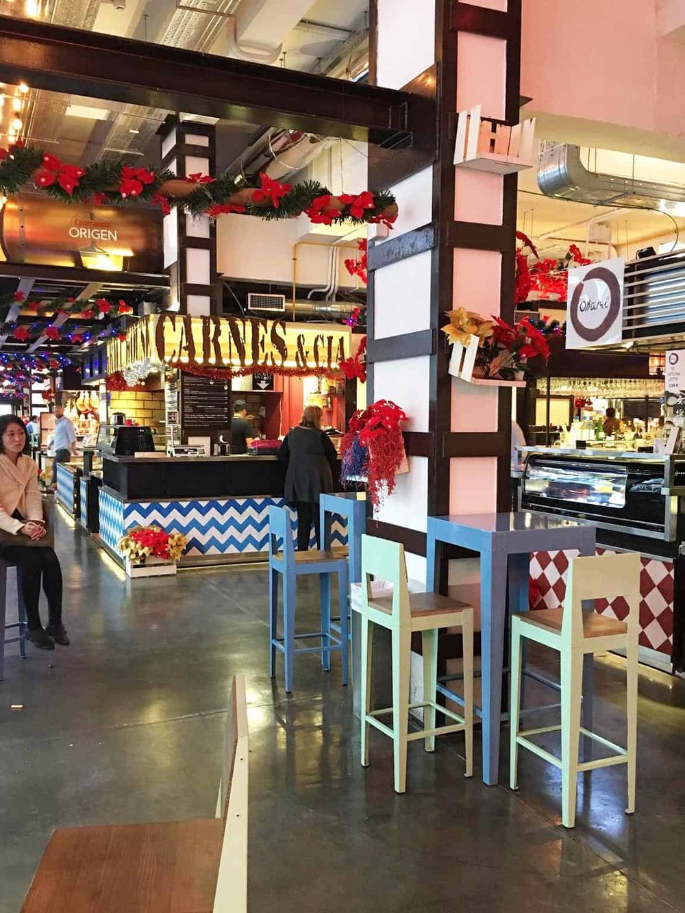 Vibrant food court at Quest for Directions mall, decorated for the holidays with festive ornaments.