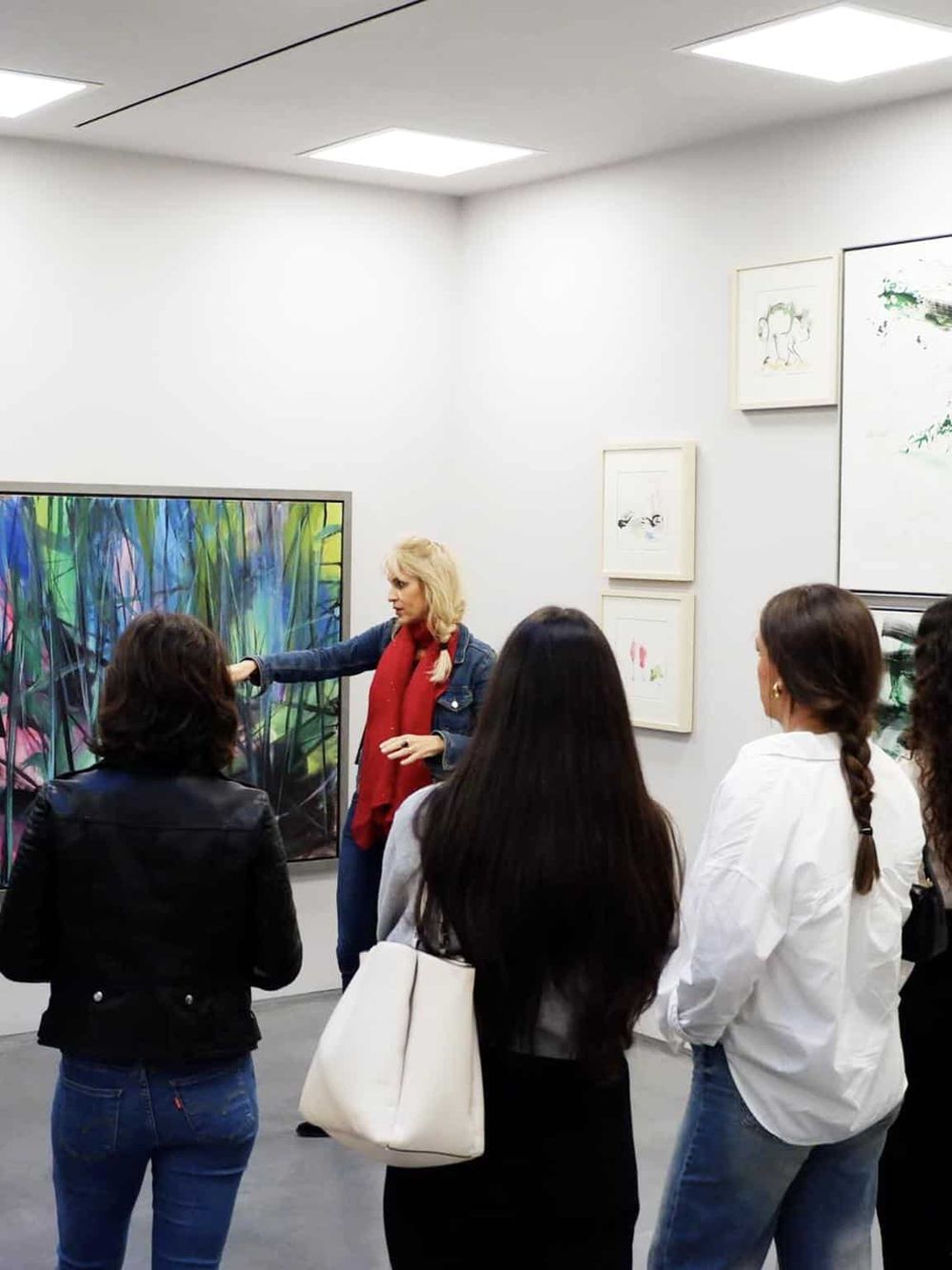 Colorful artwork art gallery event, group of women listening to guide discuss paintings, modern art display, cultural art experience at QuestForDirections.
