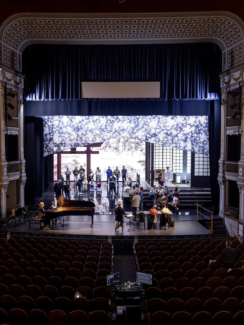 Elegant theater stage with performers and an orchestra, ready for a live performance. Perfect for concert, play, or cultural event.