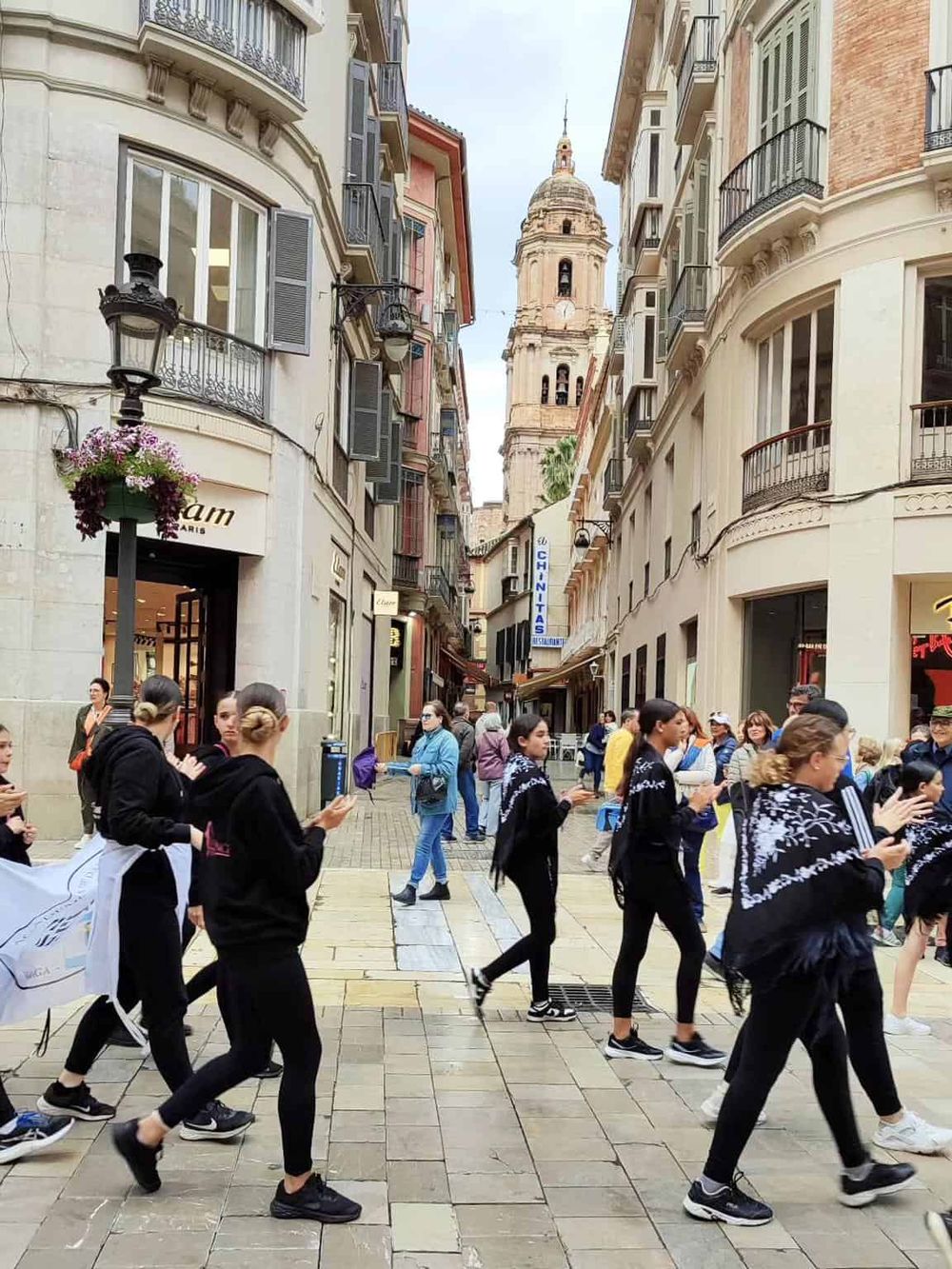 Historic European street scene with pedestrians and classic architecture, showcasing local culture and vibrant city life.