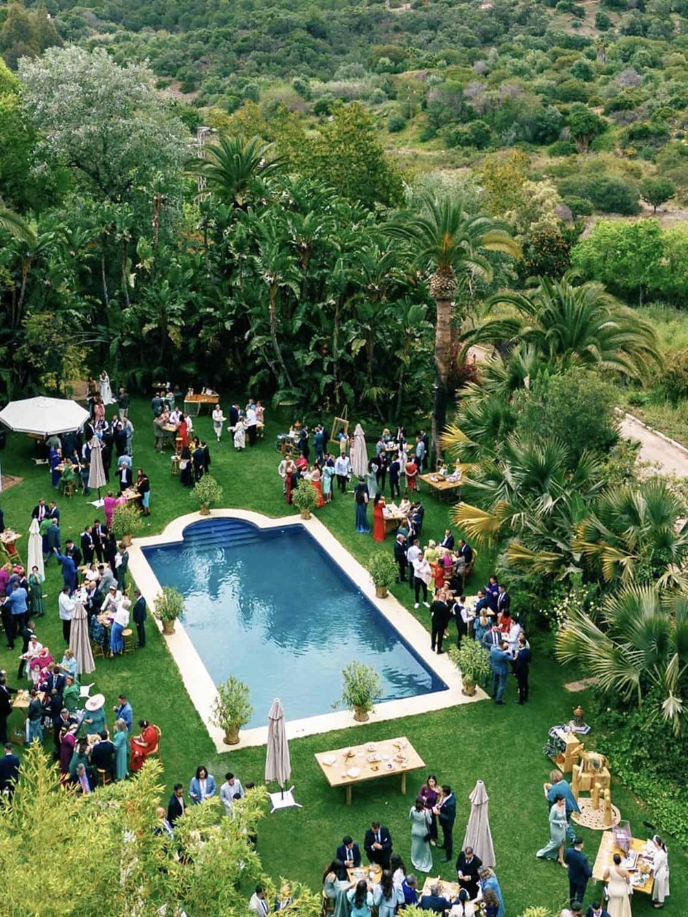 Luxury event at a lush outdoor estate with swimming pool and tropical greenery, perfect for destination wedding or corporate event.