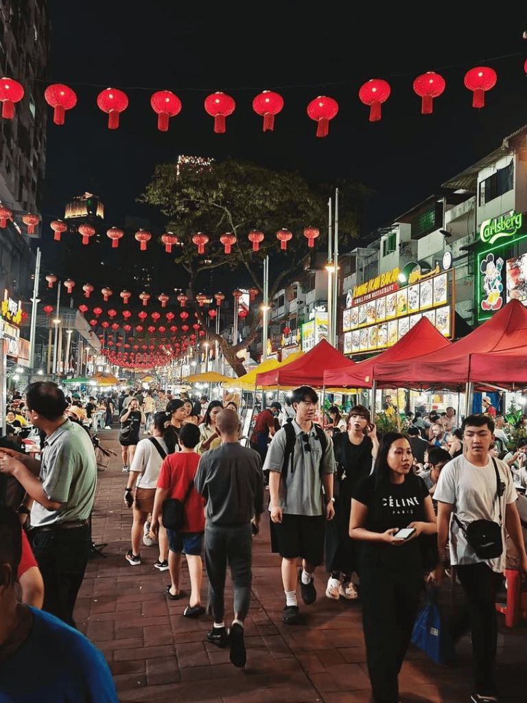 Colorful night street market with red lanterns and busy crowd, vibrant and lively nightlife scene.