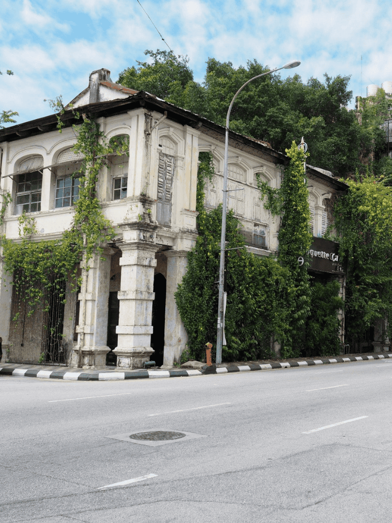 Old historic building covered in greenery along city street in quest for directions.