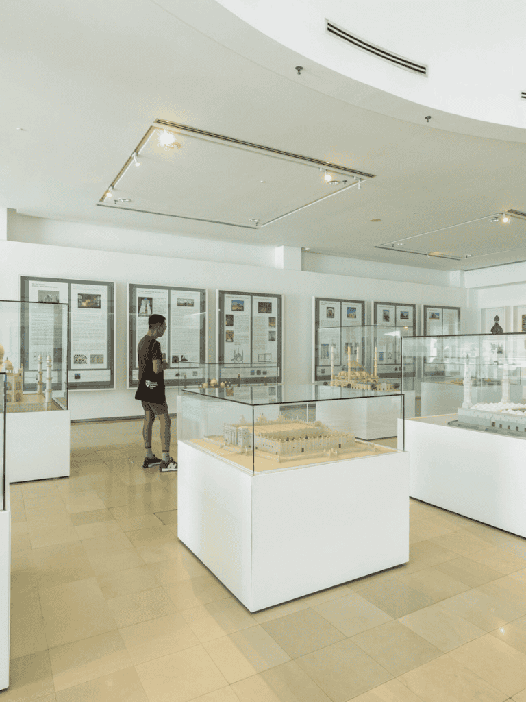 Miniature architectural models and display cases in a modern museum exhibit.