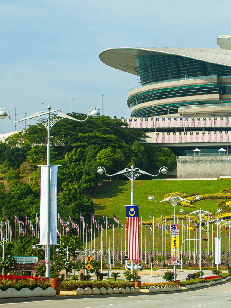 Colorful flags and Malaysia banners in front of the iconic Putra World Trade Center, Kuala Lumpur.