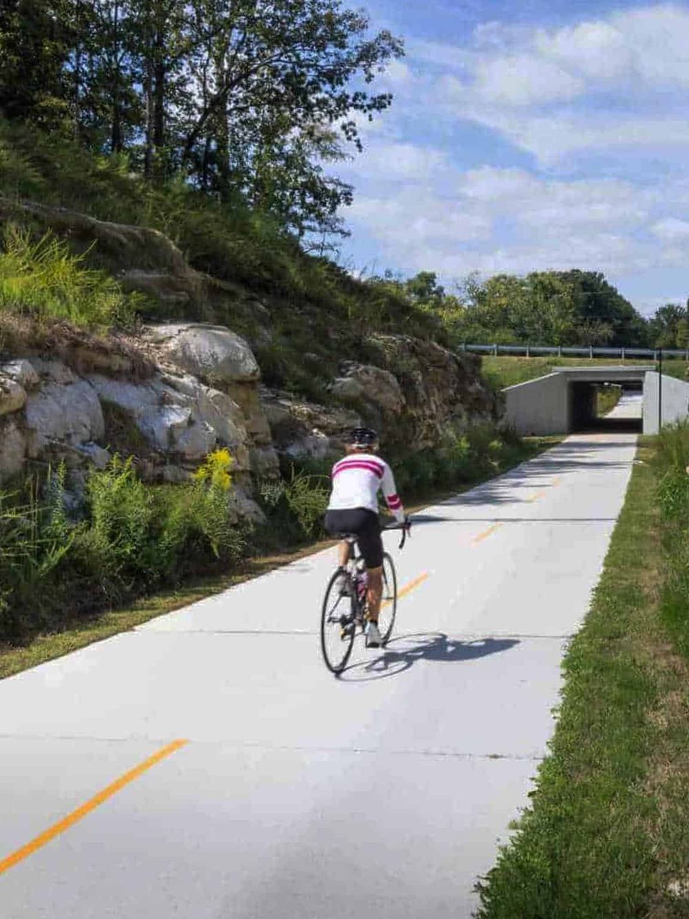 Scenic bike trail with underpass, surrounded by nature, ideal for outdoor adventure and navigation.