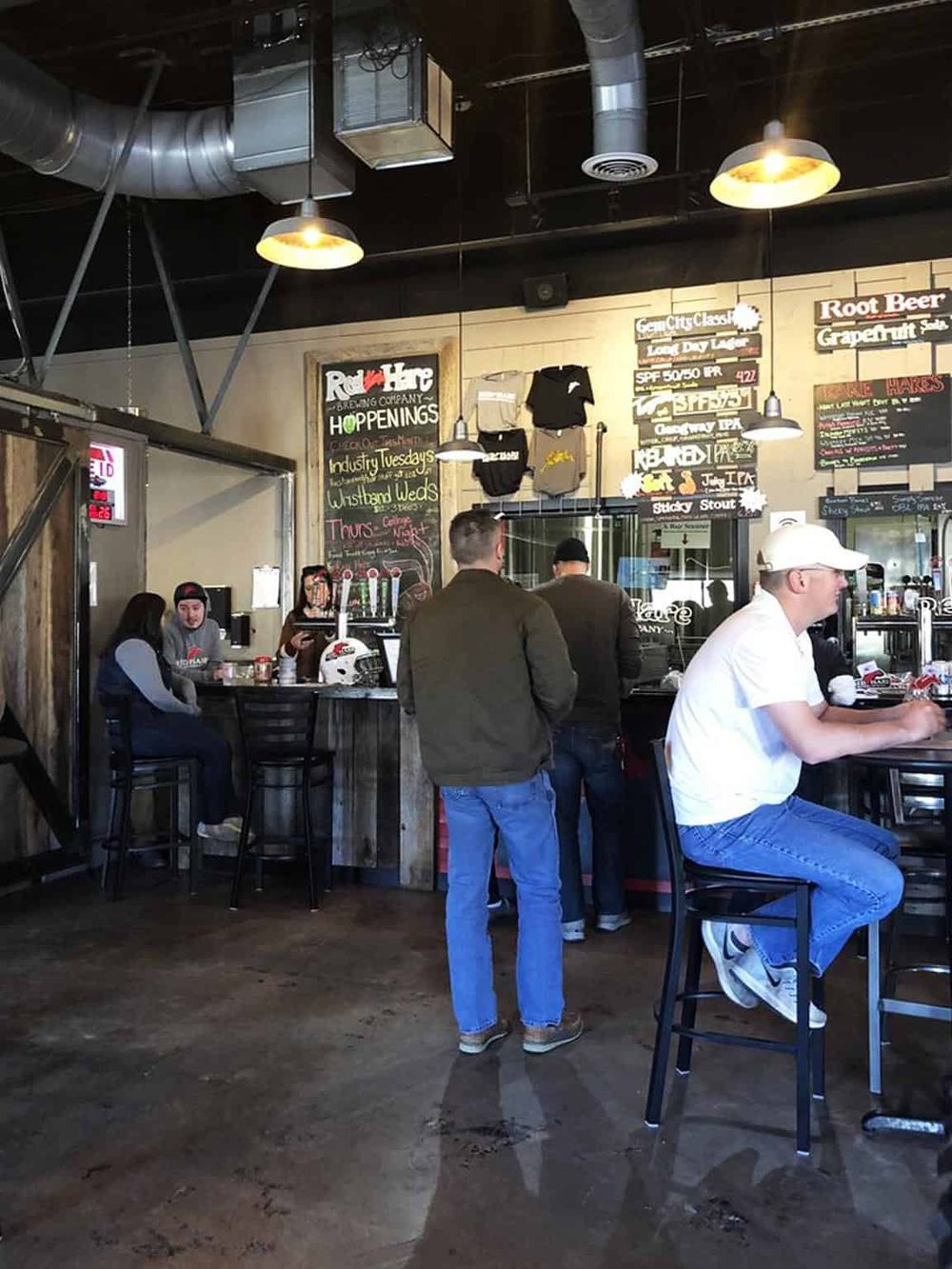 Casual brewery inside with patrons enjoying drinks, industrial décor, and craft beer offerings at QuestForDirections.
