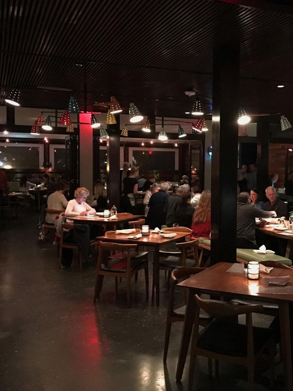 Warm inviting restaurant interior with colorful pendant lighting, surrounded by diners enjoying meals and easy navigation.