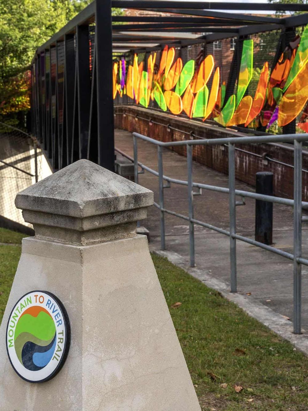 Colorful stained glass art display at the Mountain to River Trail entrance.