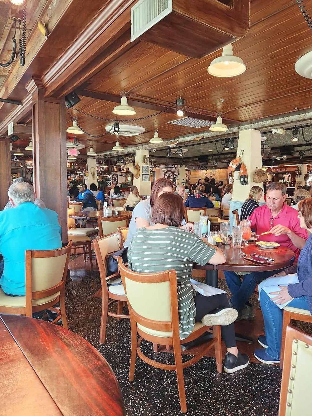 Cozy restaurant interior with wood accents and diverse patrons enjoying meals in a casual dining setting.