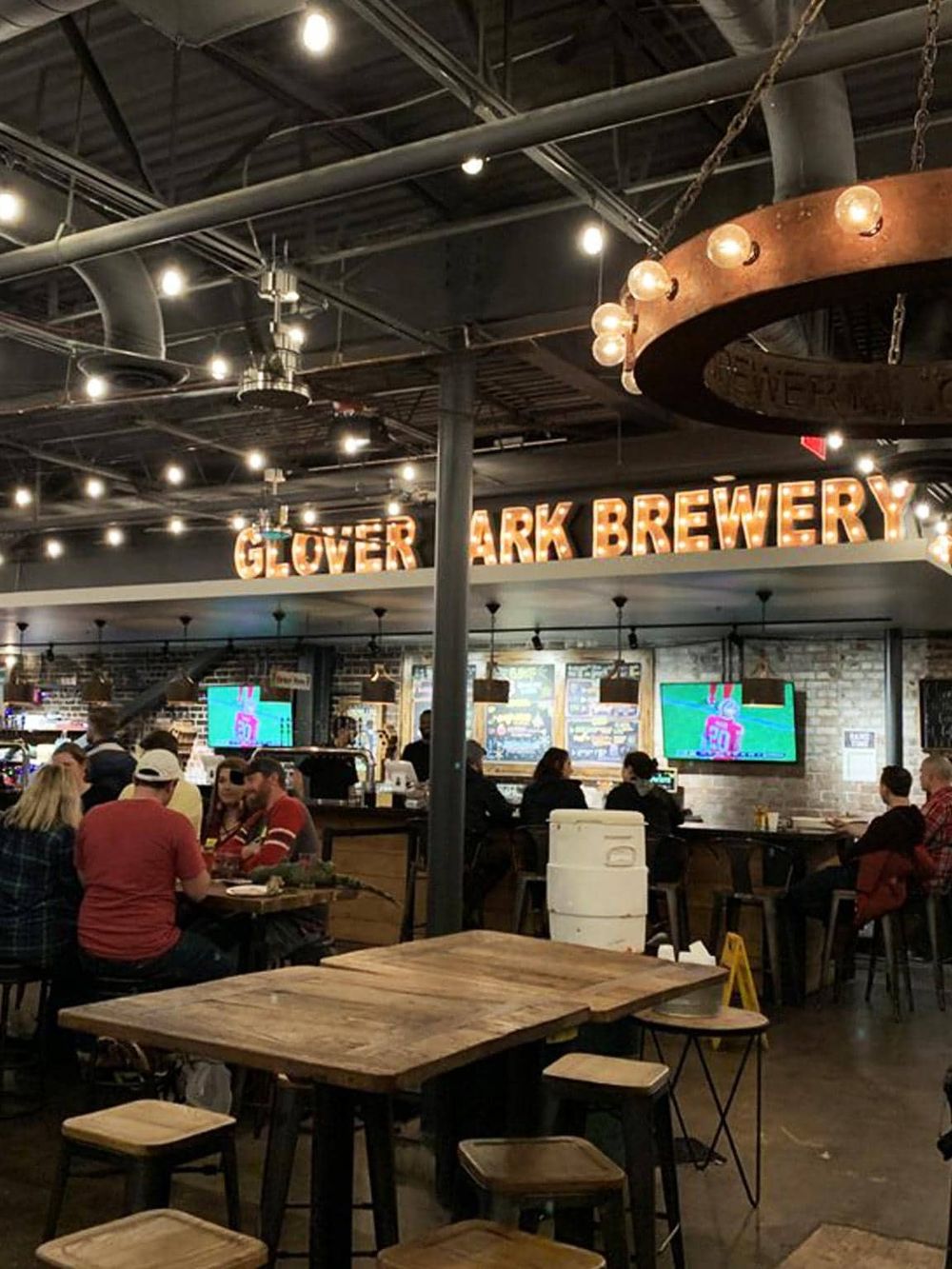 Cozy brewery restaurant with industrial decor, live TV, and social ambiance at Glover Ark Brewery.