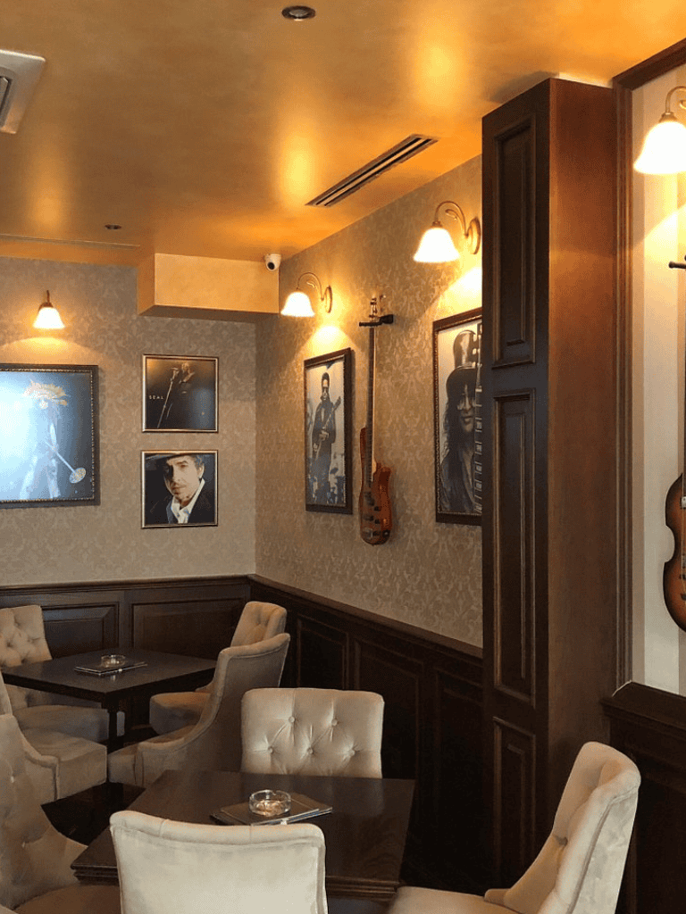Vintage music-themed restaurant interior with framed vinyl record art and acoustic guitar wall decor.