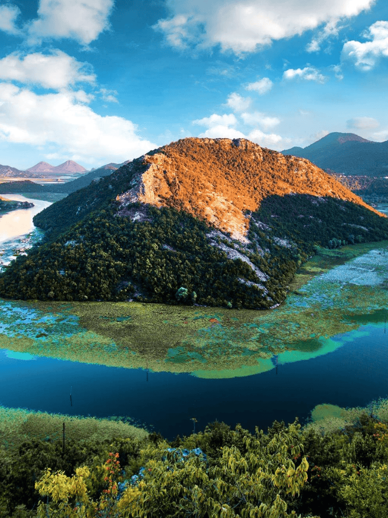 Vibrant mountain landscape with lush greenery and a serene lake, perfect for outdoor adventure and nature exploration.