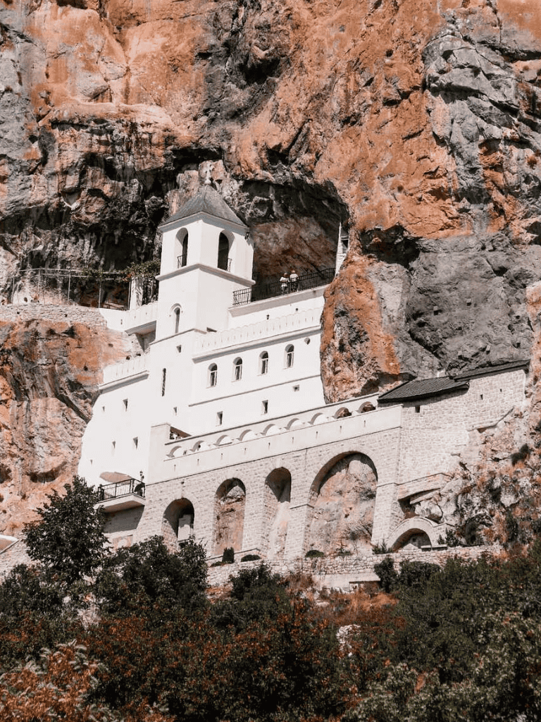 Ancient church built into a rugged mountain cliff, showcasing unique architecture and scenic views.