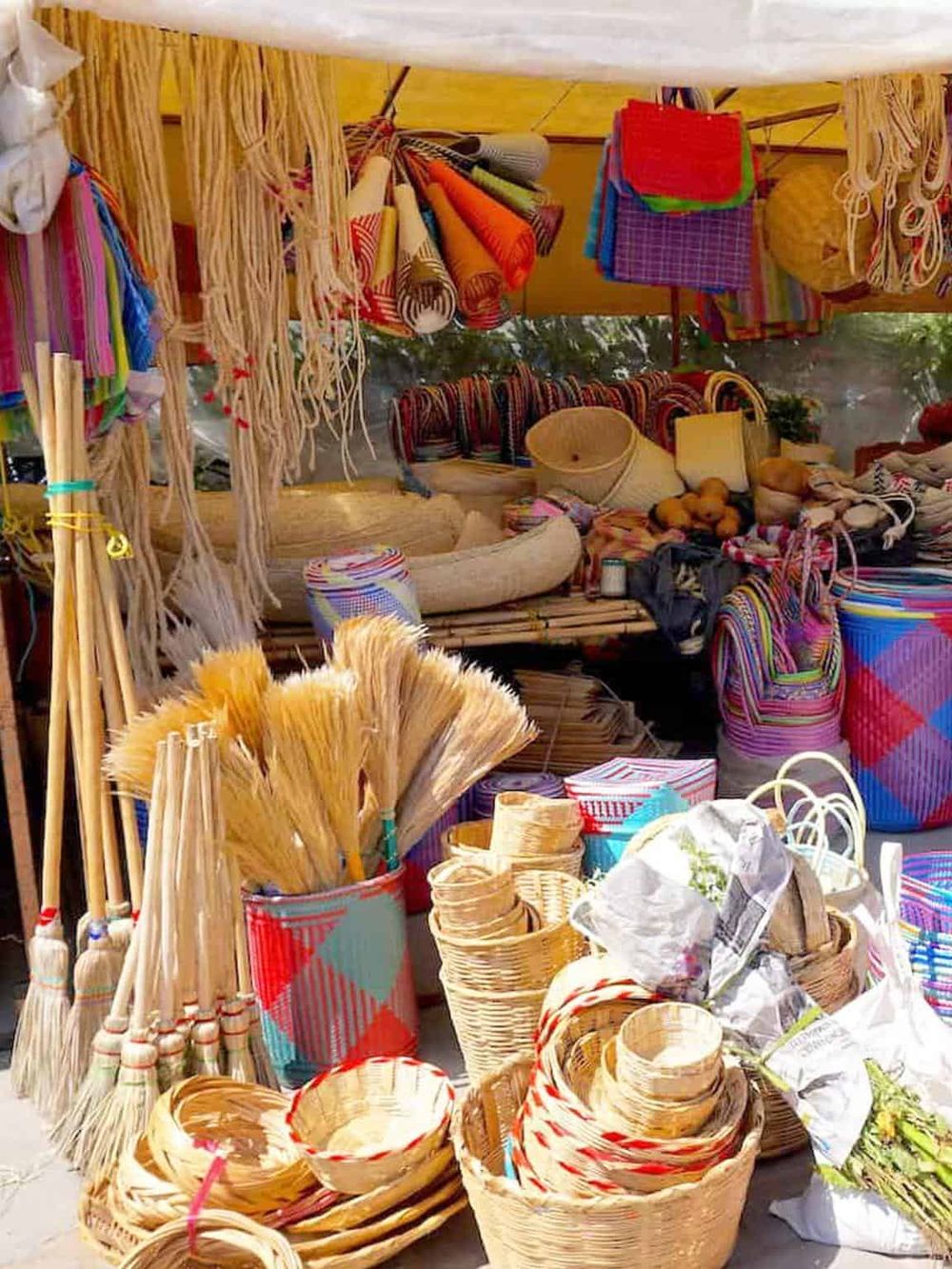 Colorful handmade basketry and woven crafts at a local market.