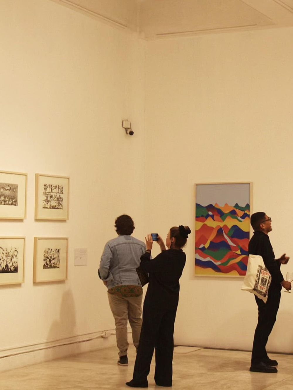 Colorful abstract artwork at an art gallery with visitors viewing and taking photos.