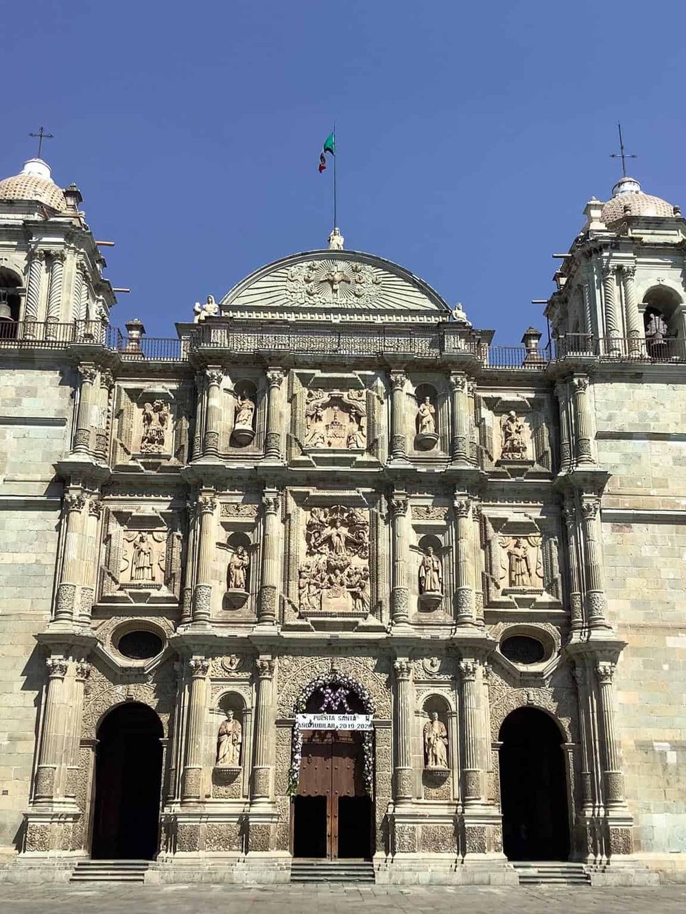 Intricate Baroque church facade showcasing elaborate stone carvings and religious statues, located in Mexico City.