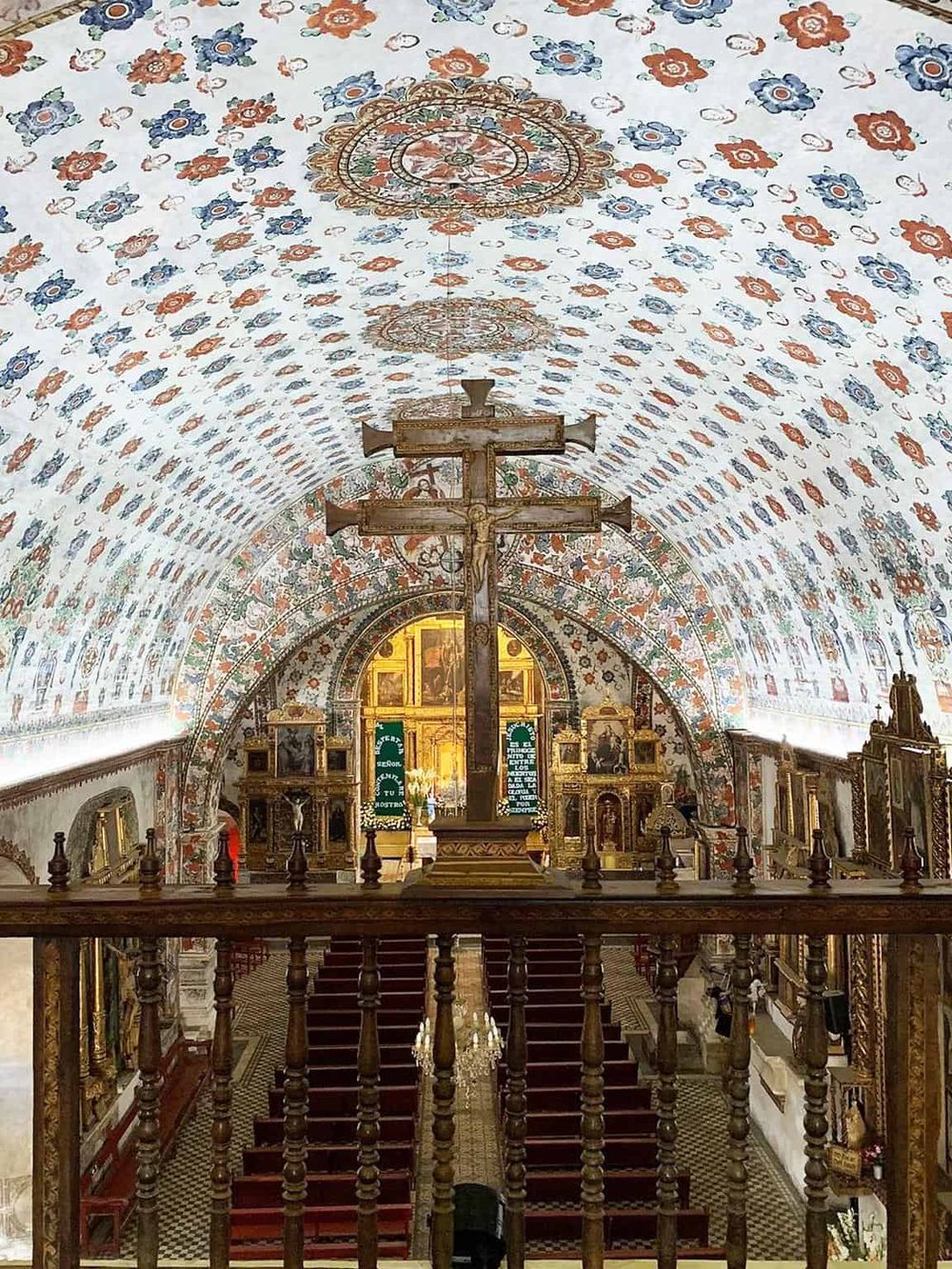 Hand-painted church ceiling with religious artwork and ornate decorations, showcasing historic religious architecture.
