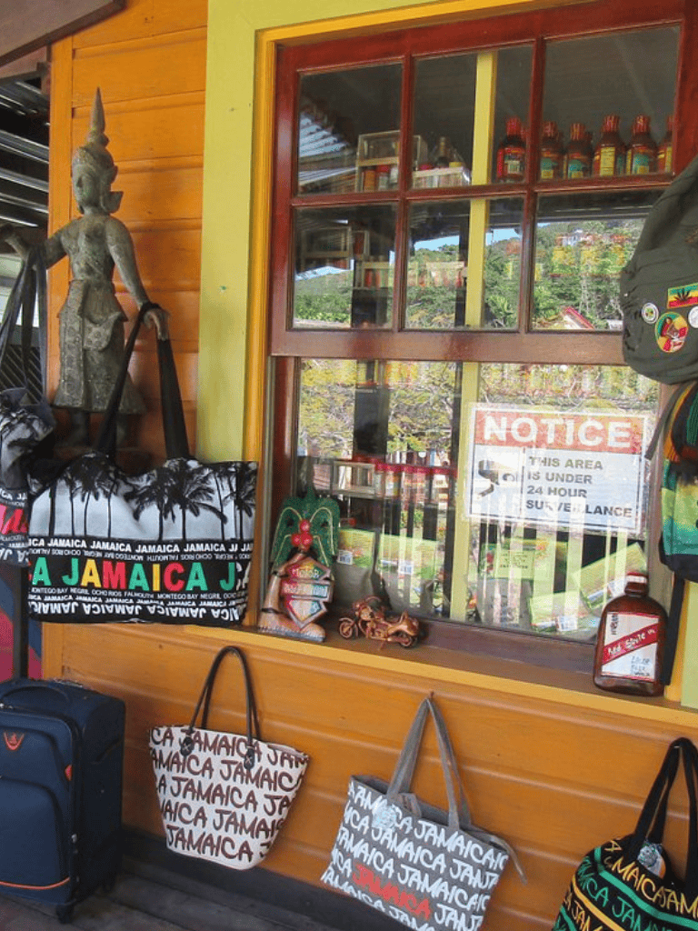 Jamaica travel souvenirs and bags at souvenir shop with colorful Jamaican theme, outdoor view.