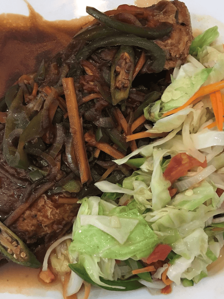Tender pork served with sautéed vegetables and fresh salad, perfect for a delicious and nutritious meal.