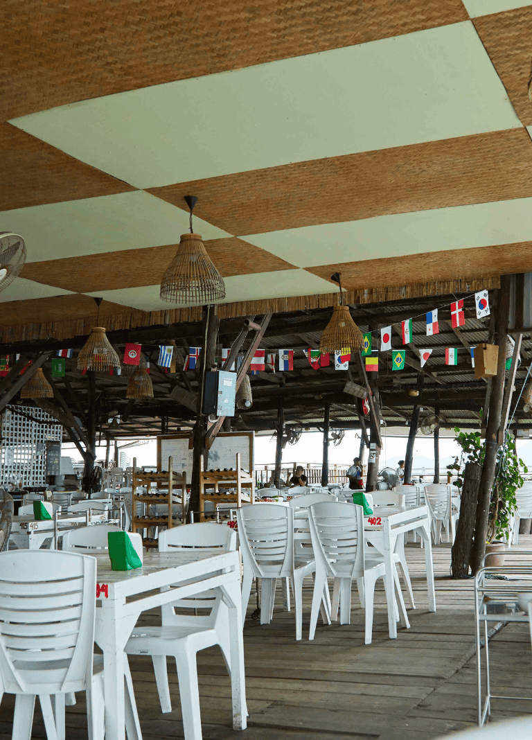Flags of various countries hanging in a tropical restaurant.