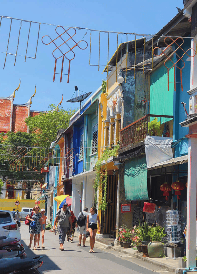 Colorful street with vibrant buildings and people walking in a lively neighborhood.