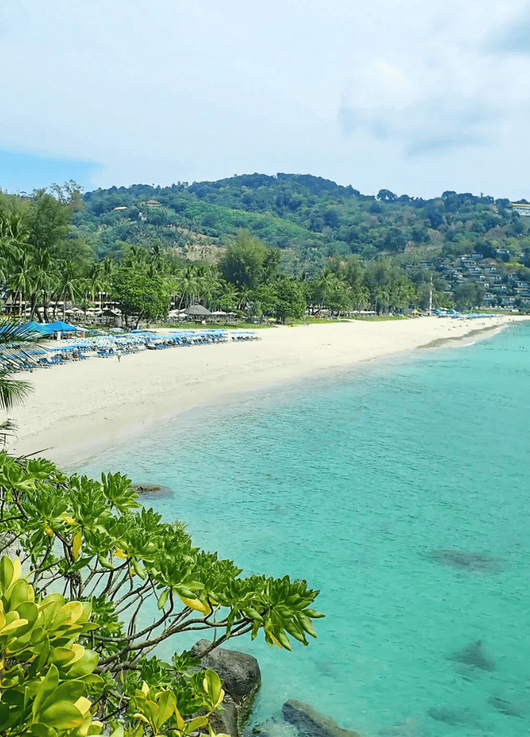 Stunning tropical beach scene with clear turquoise water and lush greenery, ideal for travel and vacation destinations.