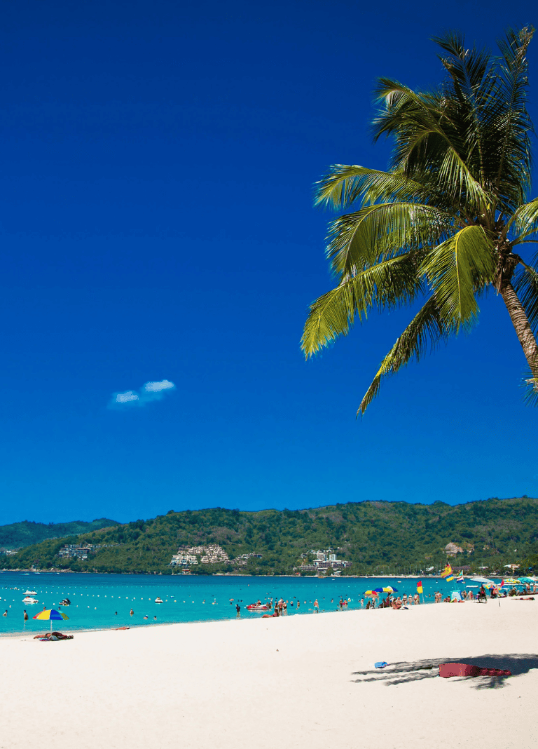 Beautiful tropical beach with palm trees, clear blue water, and people enjoying the seaside. Ideal for vacation planning and travel inspiration.