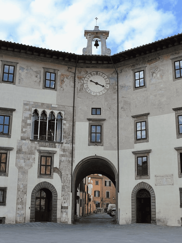 Ancient Italian building with clock tower and archway, historic architecture, scenic city street view.
