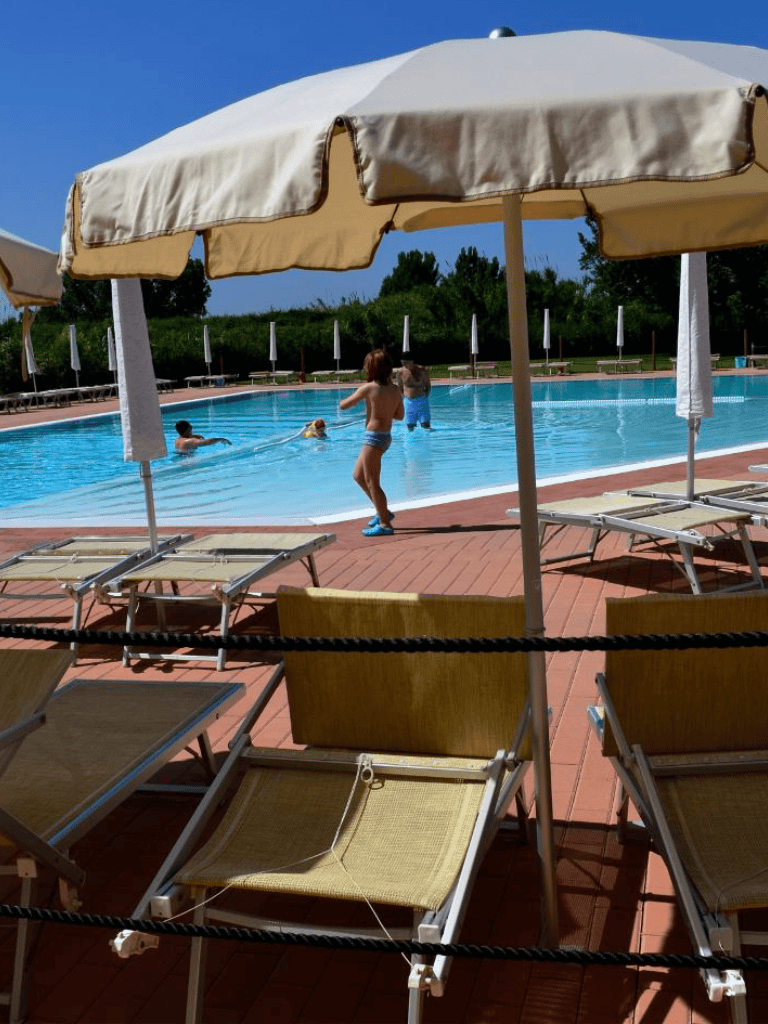 Kids playing at swimming pool on sunny day.
