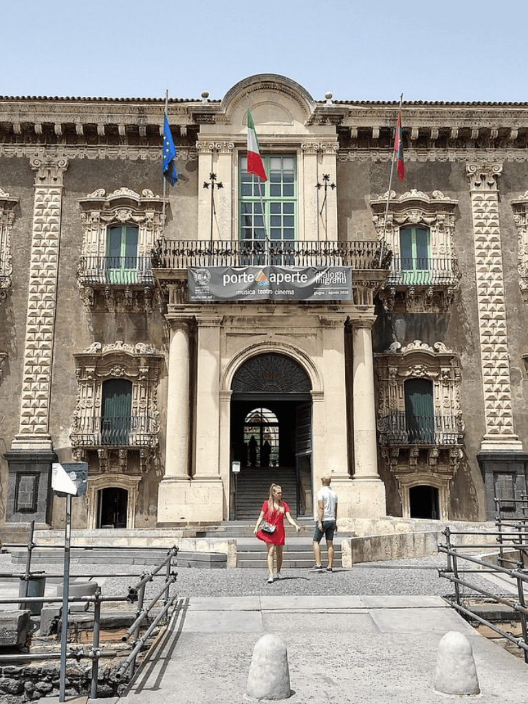 1. Historic building facade with flags and balconies in Italy, cultural landmark, architecture.
