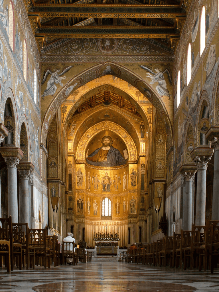 Golden interior of a historic church with religious murals and high vaulted ceilings.