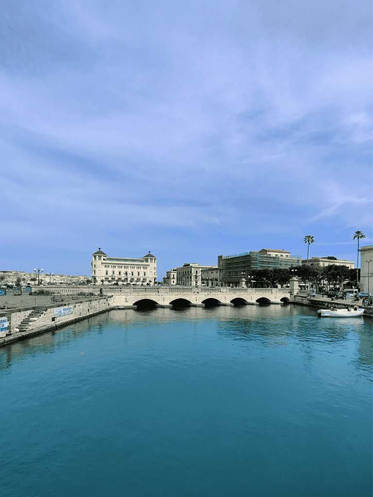 Idyllic harbor scene with historic buildings, blue sky, and calm waters in Malta, perfect for tourism and travel guides.