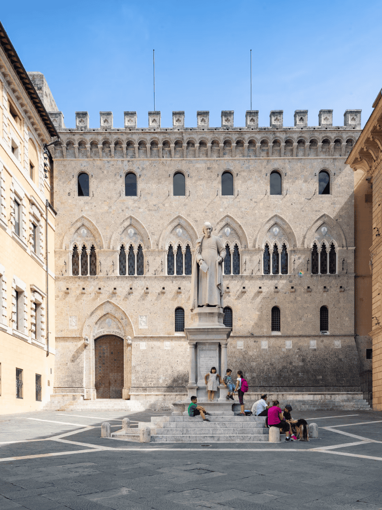 Ancient Florence cathedral with children gathering around a historic statue at Piazza della Signoria.