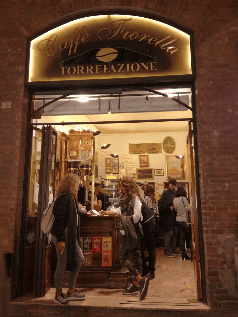 Coffee shop exterior with people inside, cozy atmosphere, and vintage decor.