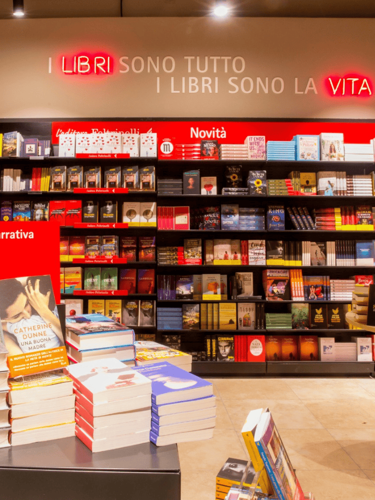 Bookshelf display at a bookstore with top sign "I LIBRI SONO LA VITA" (Books are life) emphasizing book shopping.