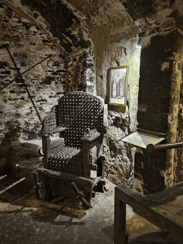 Ancient medieval throne inside stone castle with historical artifacts, rustic atmosphere.