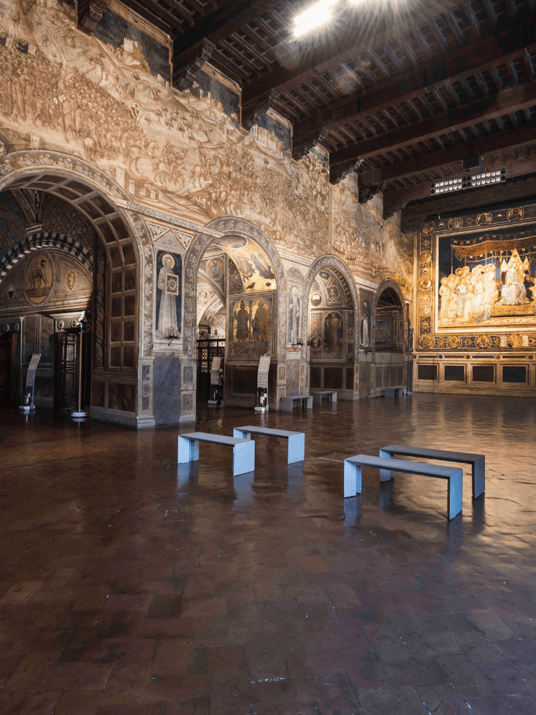 Ancient church hall with ornate murals, arches, and wooden ceiling, exploring historical art and architecture.